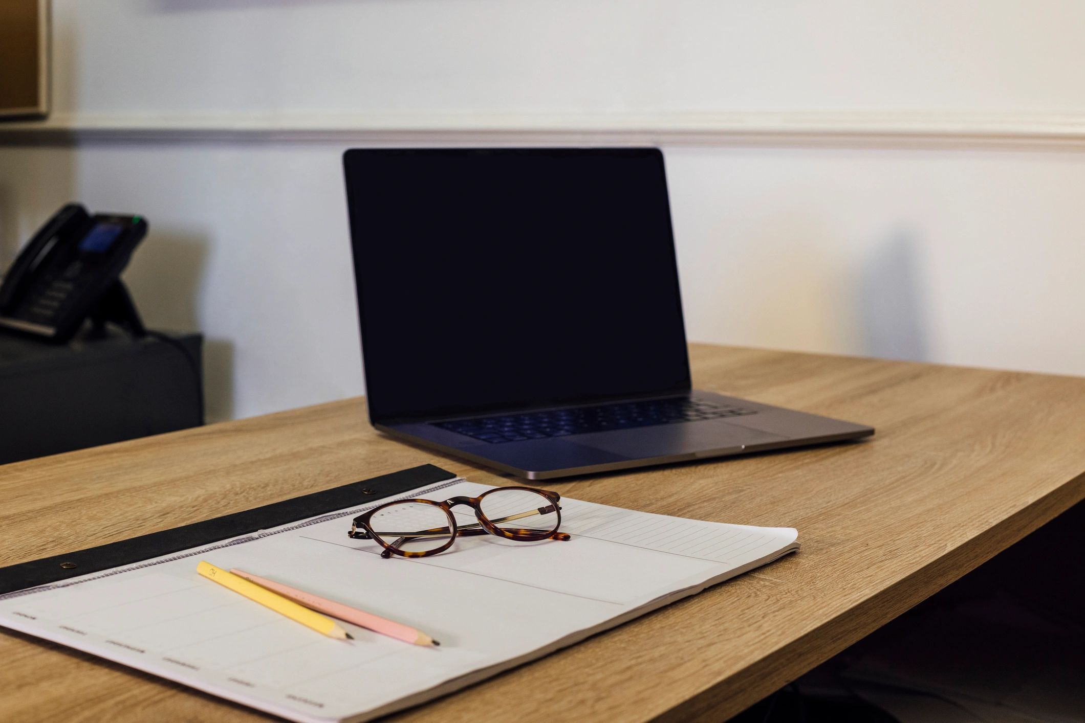 Laptop and planner on a desk, representing workout planning and coaching support.