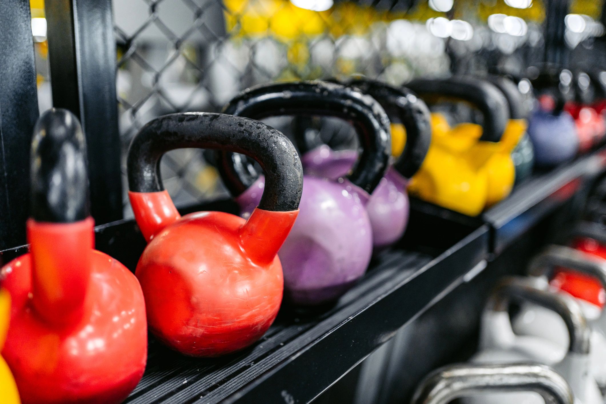Kettlebells arranged on a gym floor.