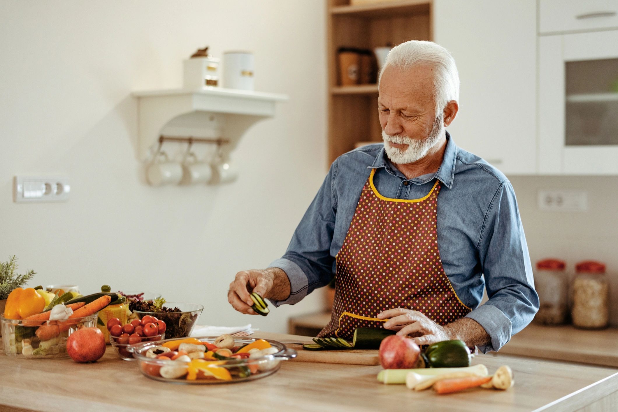 Senior man preparing a healthy meal in a home kitchen