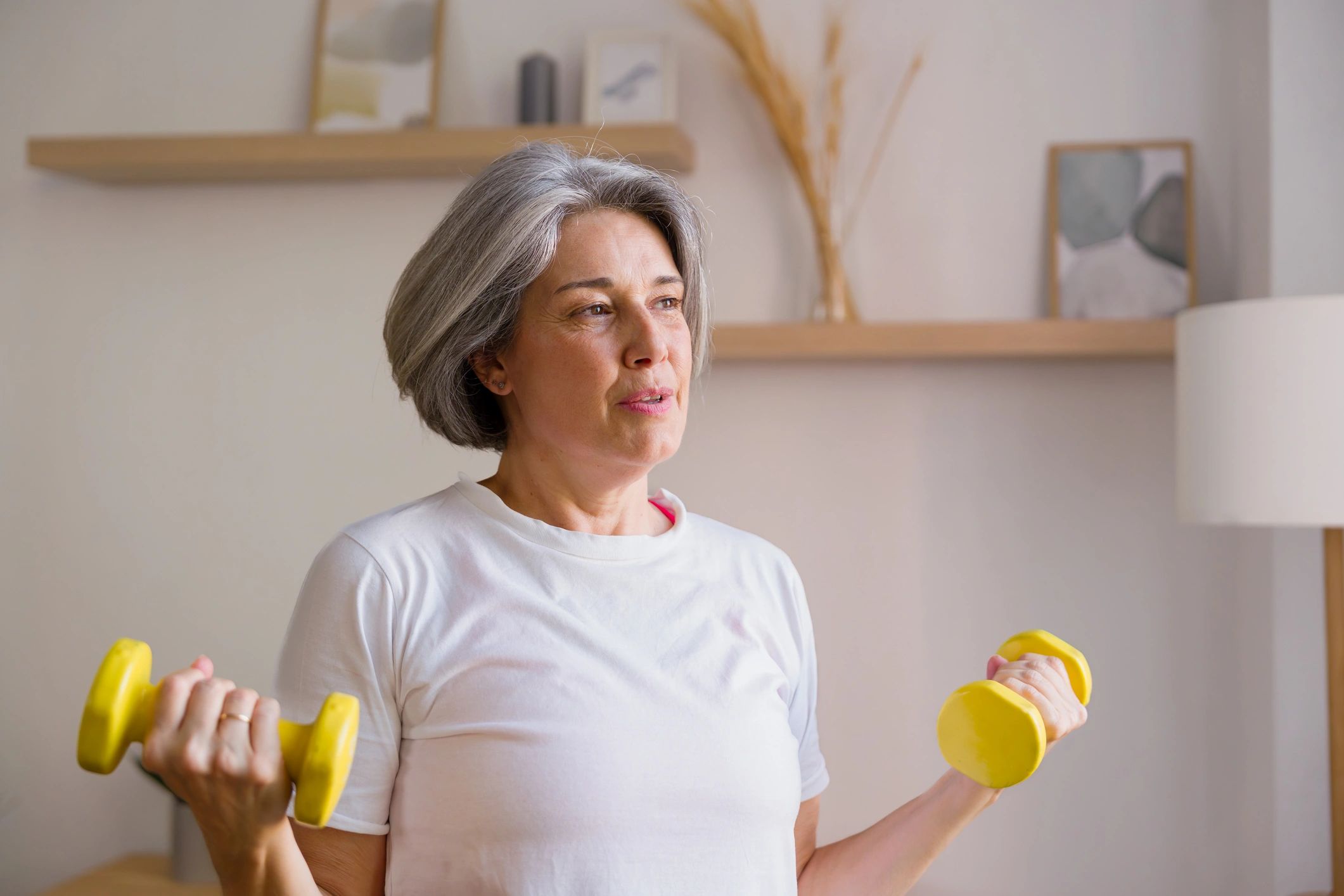 Senior woman doing a dumbbell workout at home